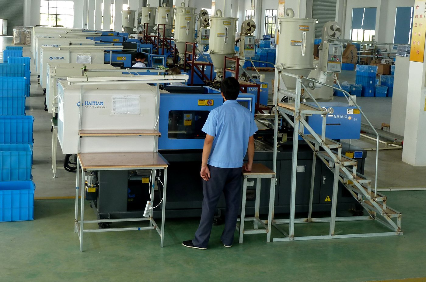 A row of Haitian injection molding machines with material dryers